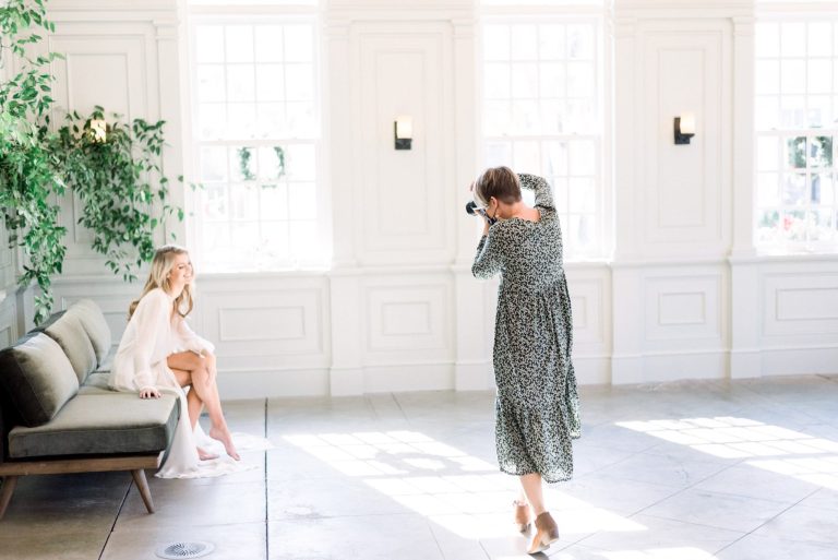 photographer photographs model sitting on green couch in robe