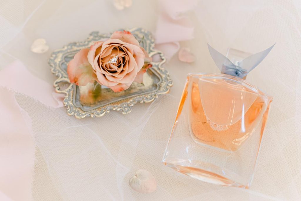 close up of engagement ring and bottle of perfume