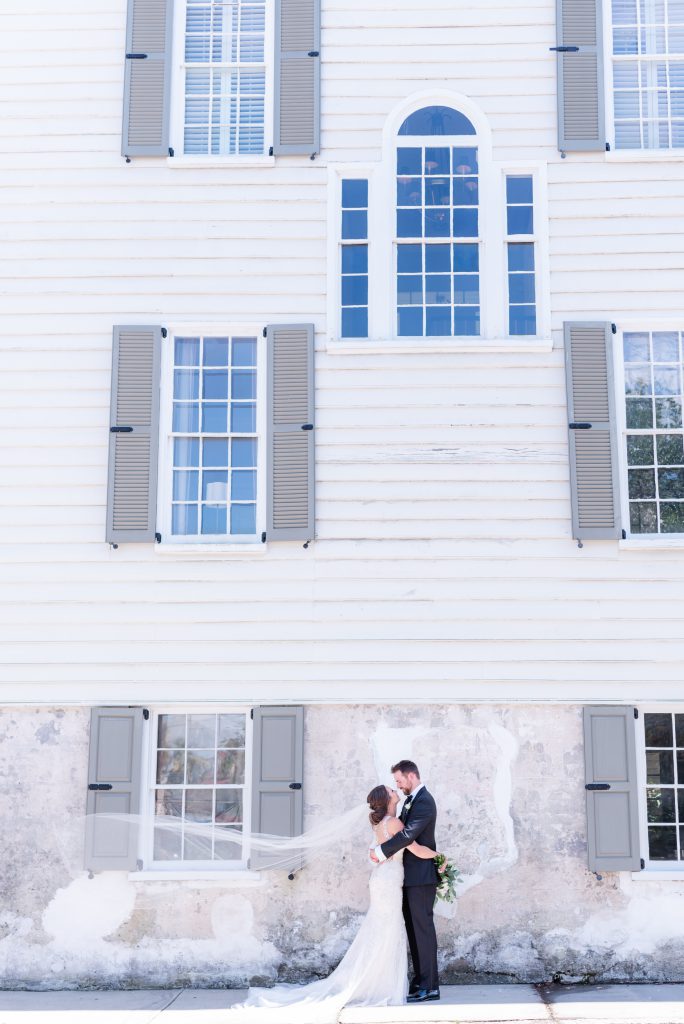 bride and groom posed by exterior of The Gadsden House