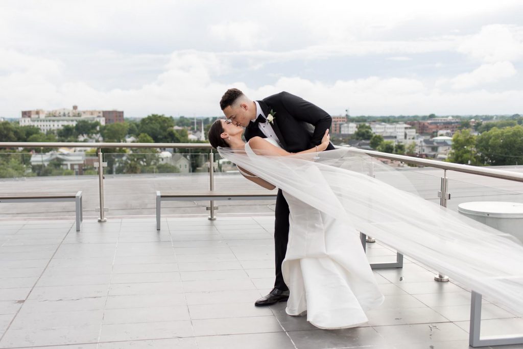 groom dips bride for kiss at The Cedar Room rooftop wedding