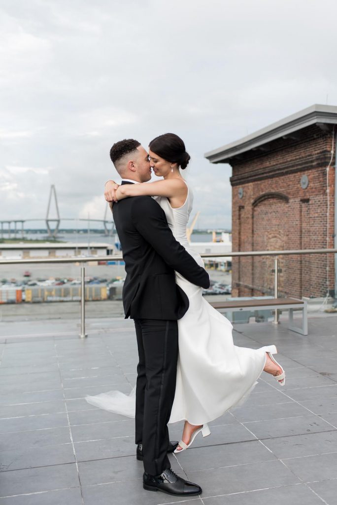 groom picks up bride romantically on rooftop of The Cedar Room Charleston