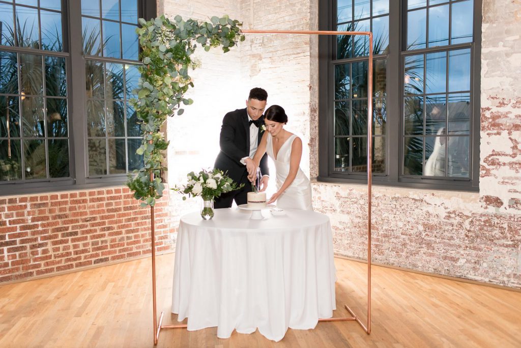 couple cuts wedding cake at rustic Cedar Room wedding