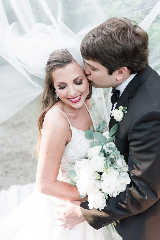 groom kisses brides temple under her veil