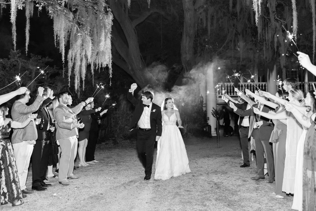groom cheers during sparkler exit from his wedding