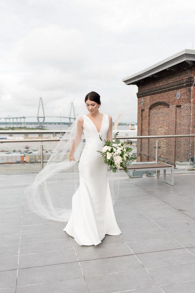 bride waving long veil in wind on rooftop of Cedar Room