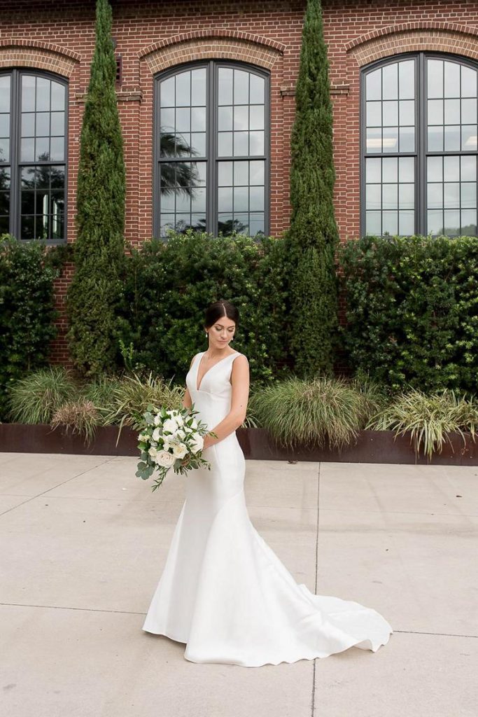 brunette bride looking over shoulder in outside courtyard