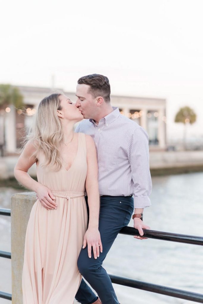 Engaged couple kiss at the Battery overlooking water