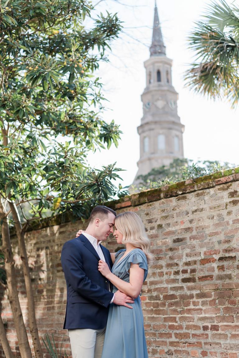 couple forehead to forehead with church steeple in background