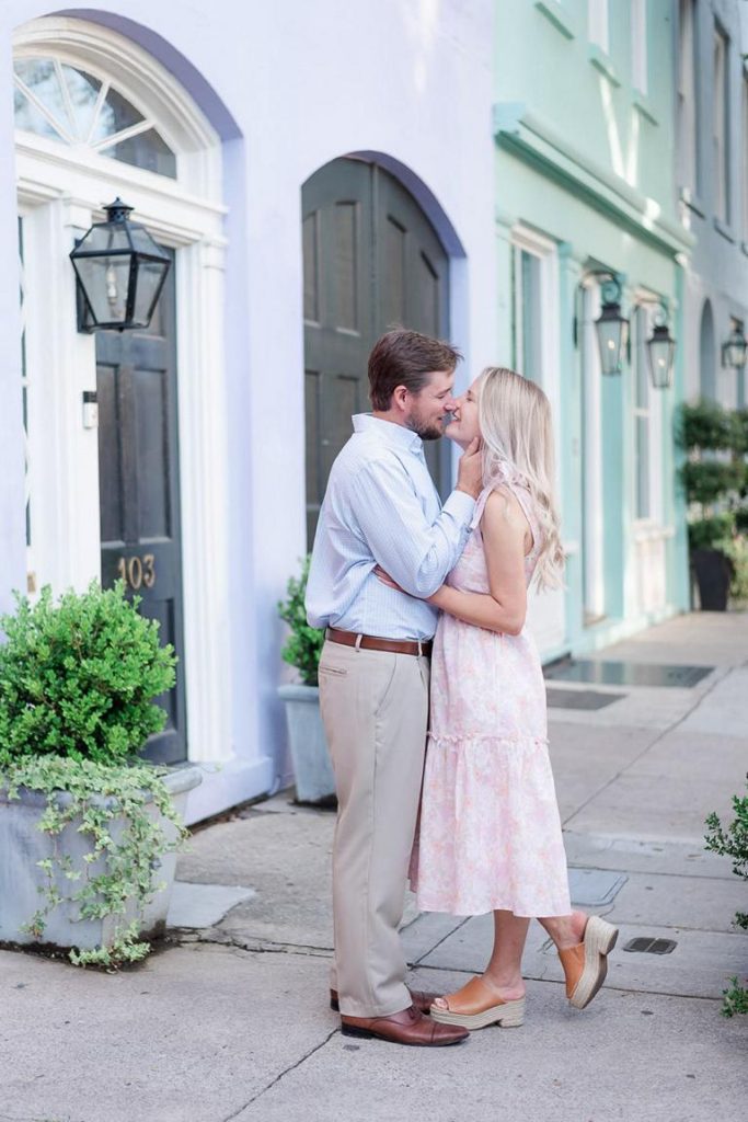 Engaged couple kissing at Rainbow Row Charleston, SC