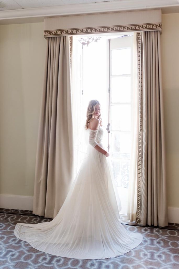 full length bridal portait in front of balcony door at the Mills House Hotel