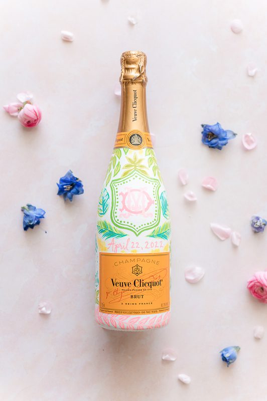 painted colorful bottle of champagne against pink backdrop