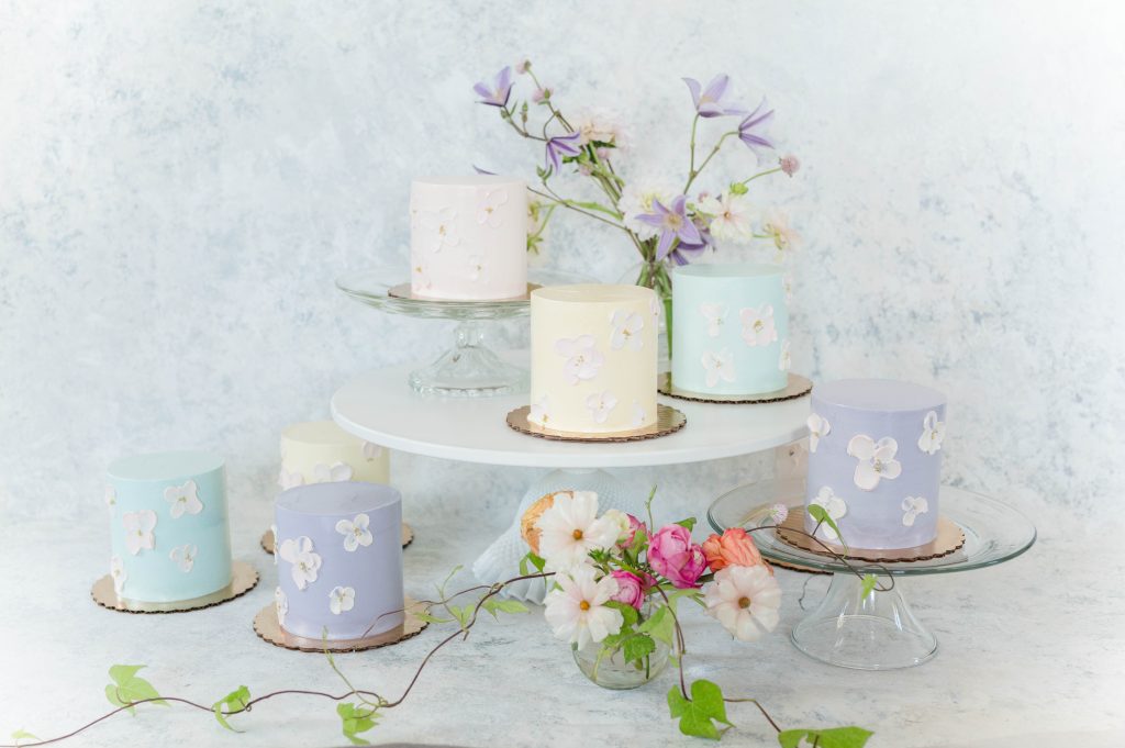 multiple petite pastel cakes on cake stand