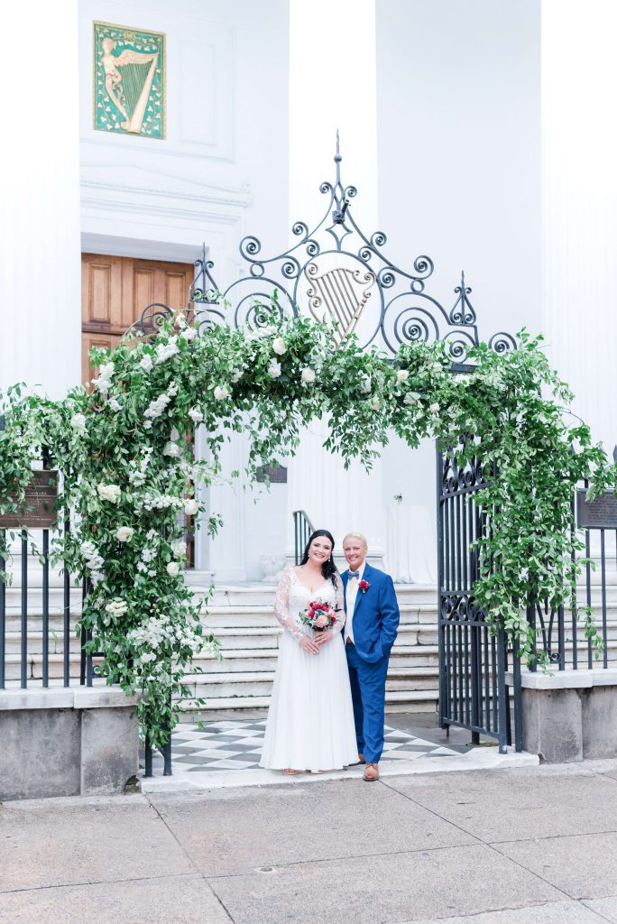 Brides stand under floral arch in downtown Charleston SC