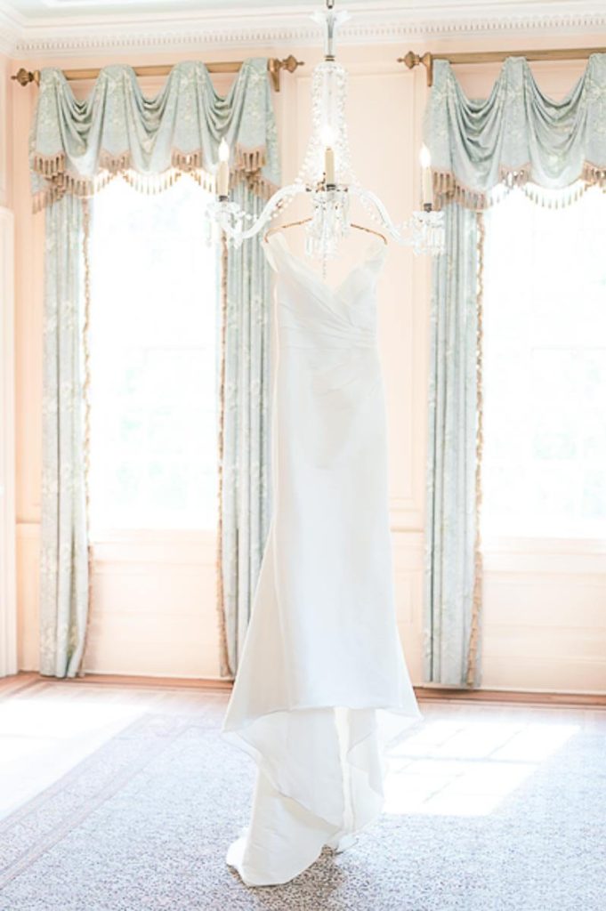 wedding dress hanging from chandelier inside Lowndes Grove House