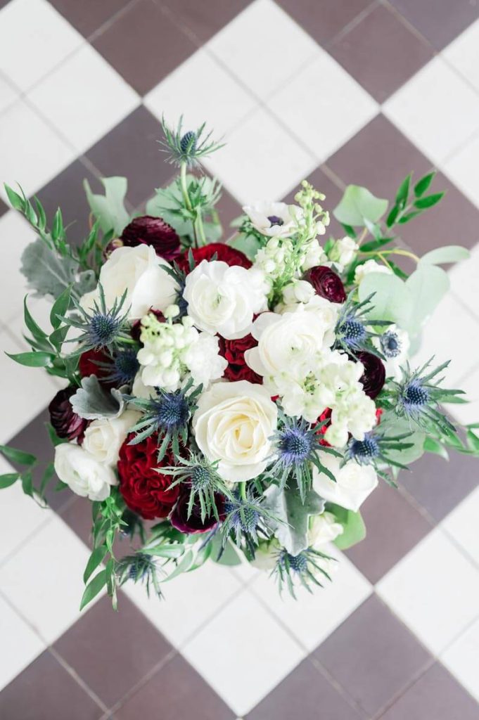 wedding bouquet of white and red roses and blue thistle
