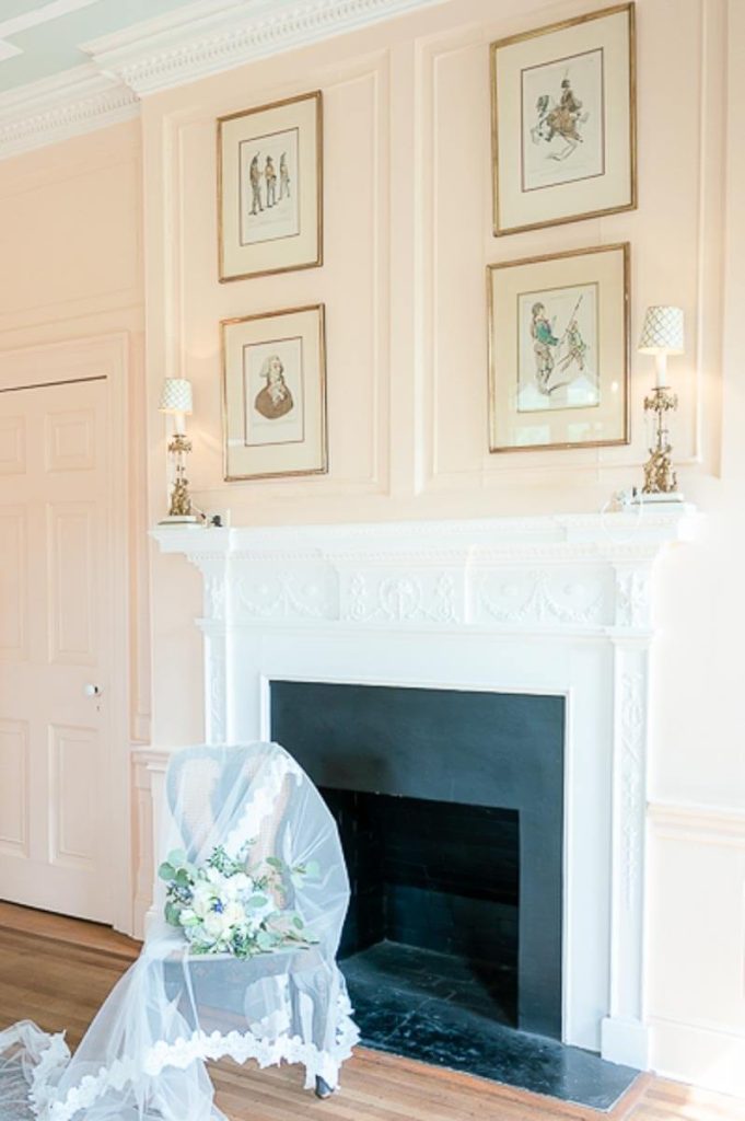 Wedding Veil and bride's bouquet draped on chair in front of fireplace at Lowndes Grove House