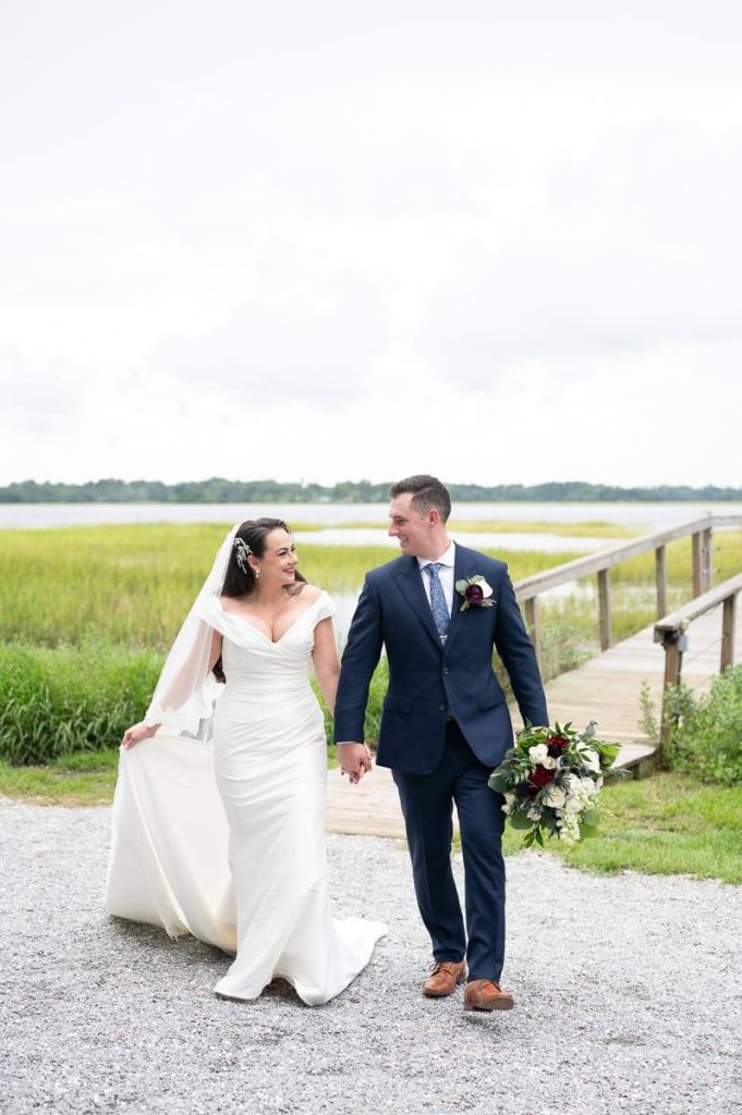 newlyweds walk away from waterfront towards reception
