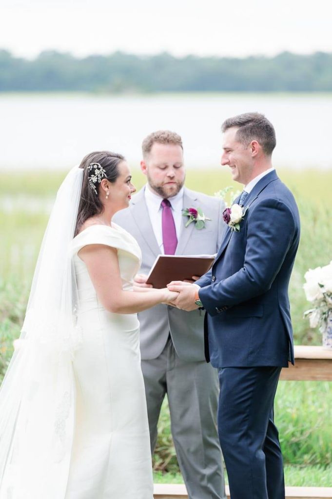 bride and groom hold hands during outdoor wedding ceremony