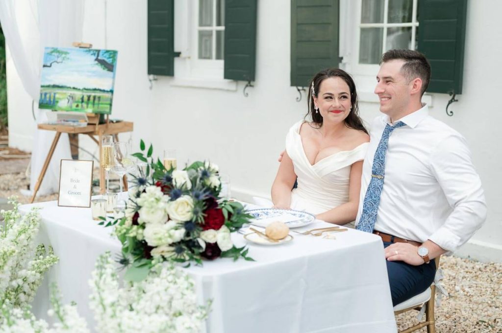 newlyweds listen to wedding speeches at head table