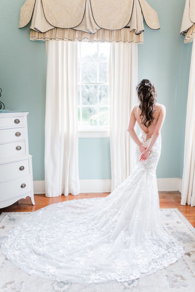 full length photo of bride holding hands behind her back with dress flared out behind her