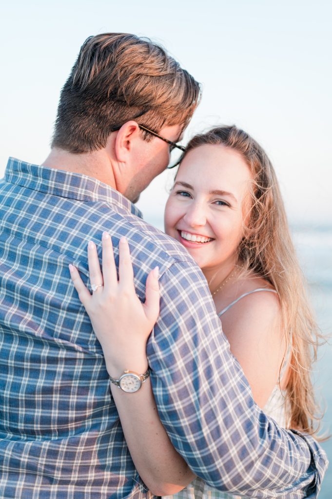newly engaged couple hugging at beach