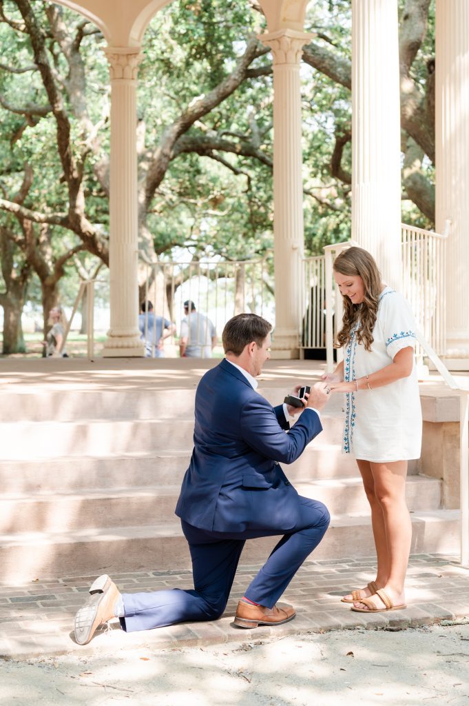 guy sliding ring on girlfriends' finger after proposing