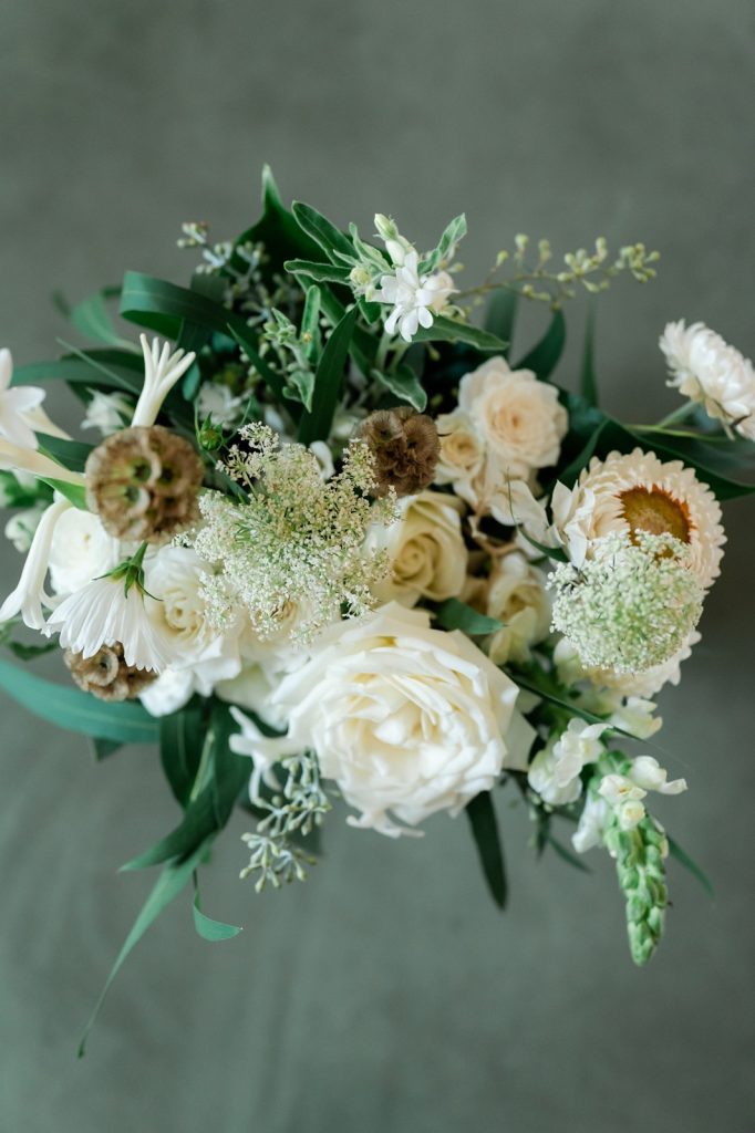 close up of bridal bouquet on green velvet couch