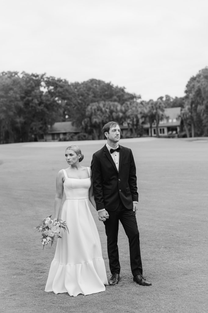 bride and groom stare off in the distance in opposing directions