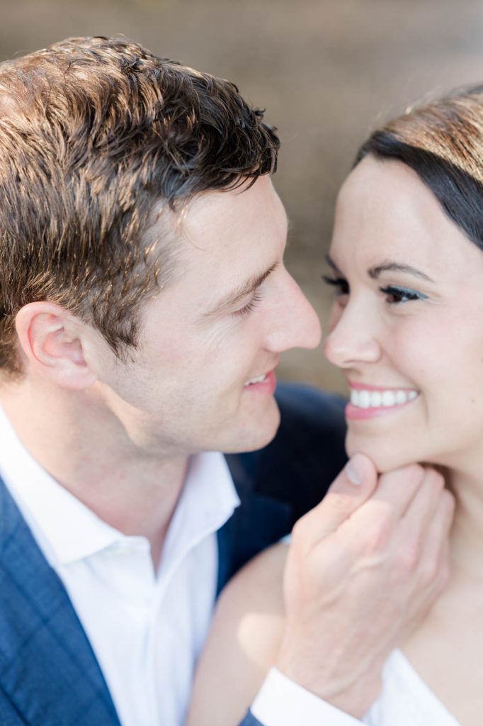 guy grabs chin of fiancé to bring her in for a kiss