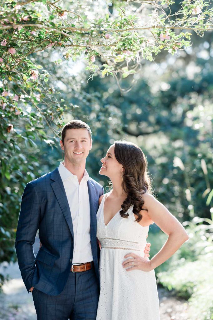 girl looks on at fiance on grounds of Magnolia Gardens