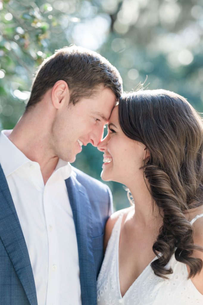 couple stand nose to nose smiling