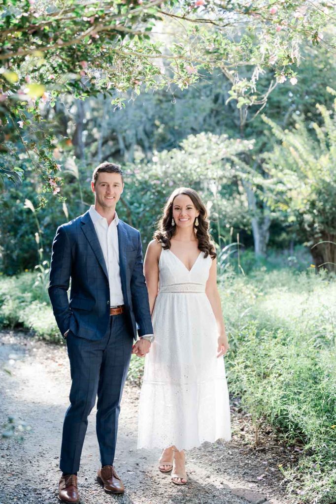 couple stroll hand in hand through garden