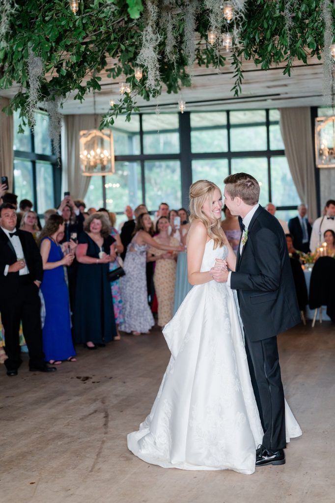 newlyweds smile at each other during first dance