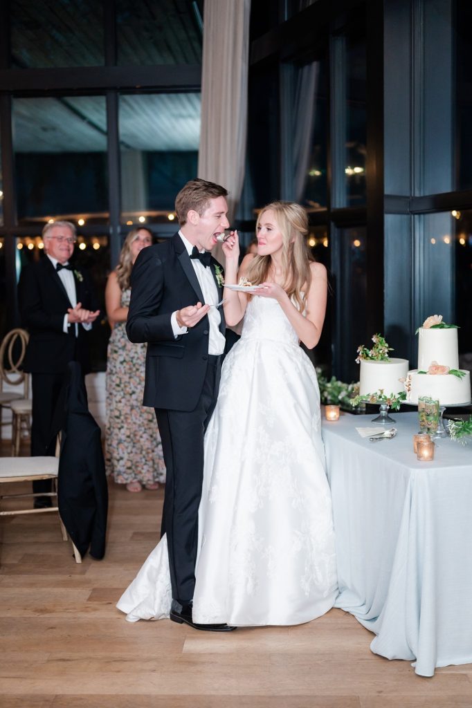 bride feeds groom a bite of wedding cake