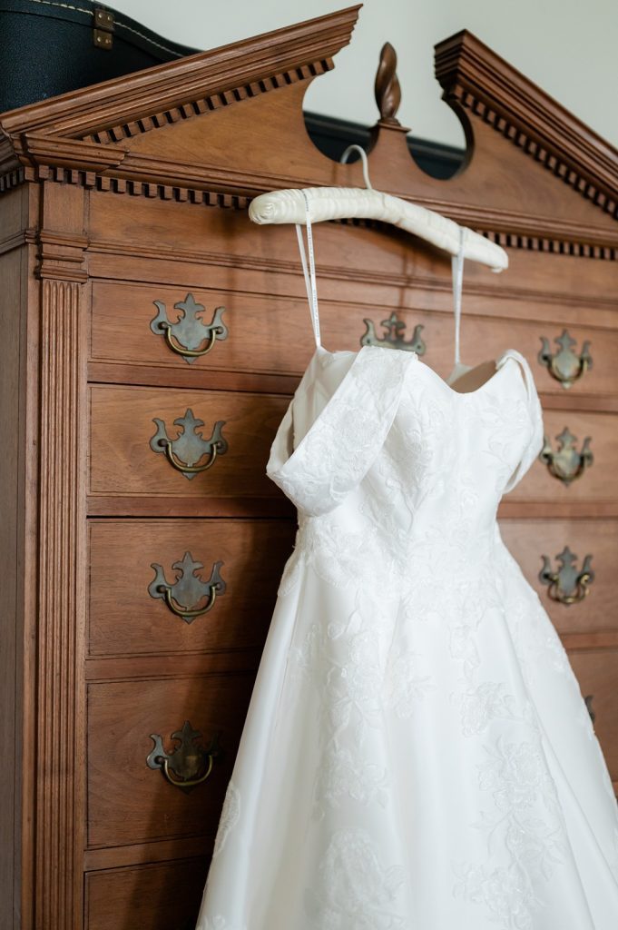 wedding dress hanging on dresser
