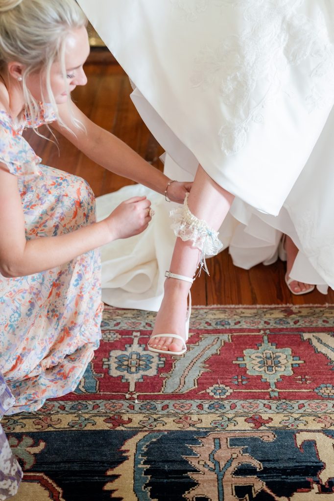 bridesmaid sliding garter on bride's calf