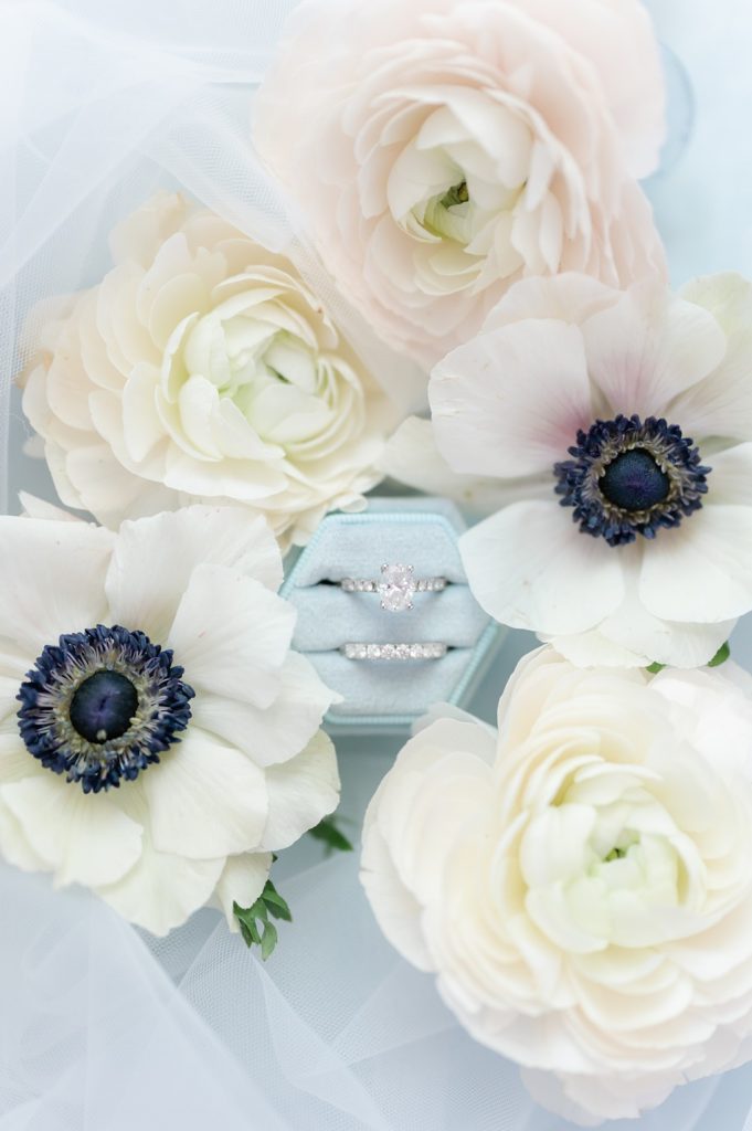 pale blue ring box with wedding rings surrounded by flowers