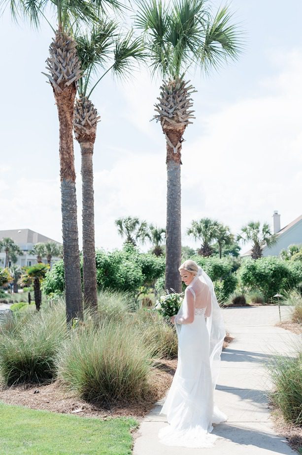 full bridal portrait of bride looking over her back and shoulder