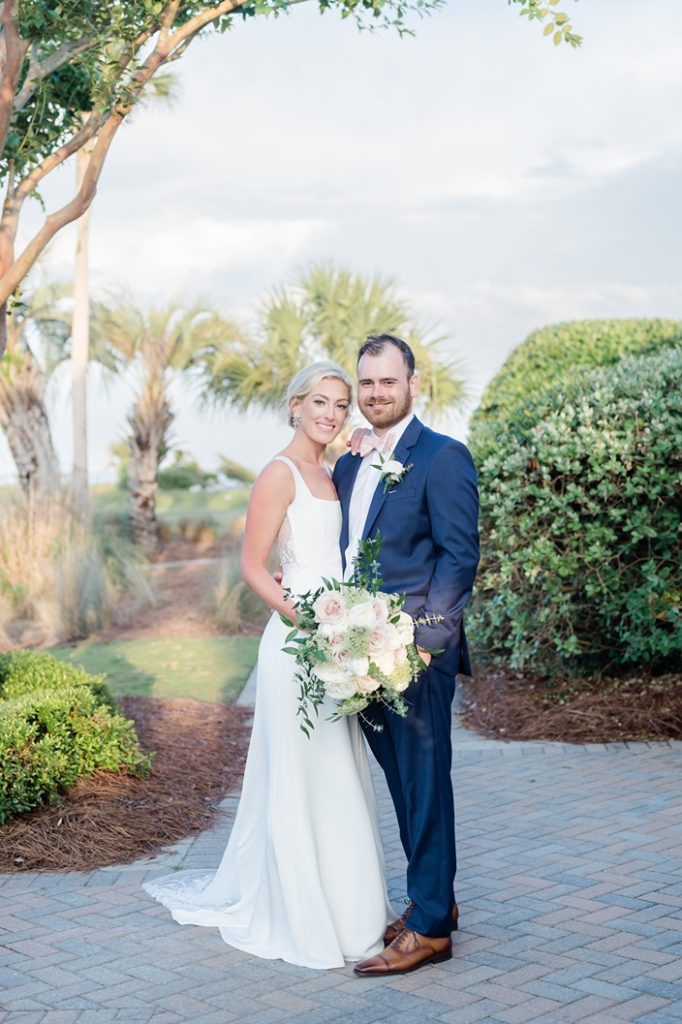 full length of newlyweds looking straight at camera