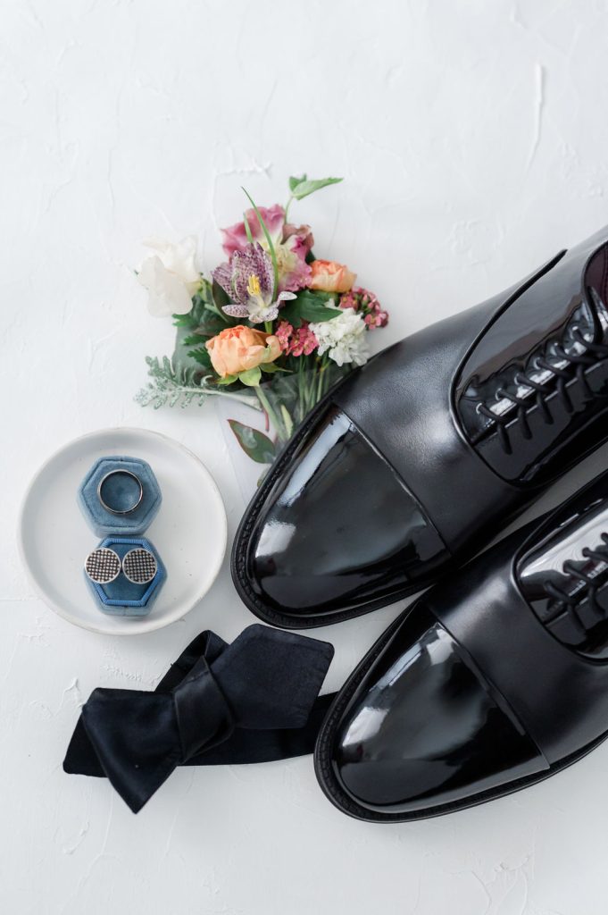 flat lay of groom details including cufflinks, ring, boutonniere, and shoes