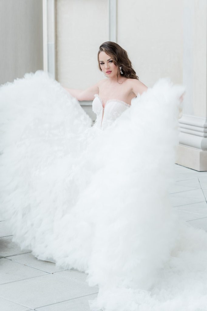 bride holding out sides of tulle Martina Liana wedding gown