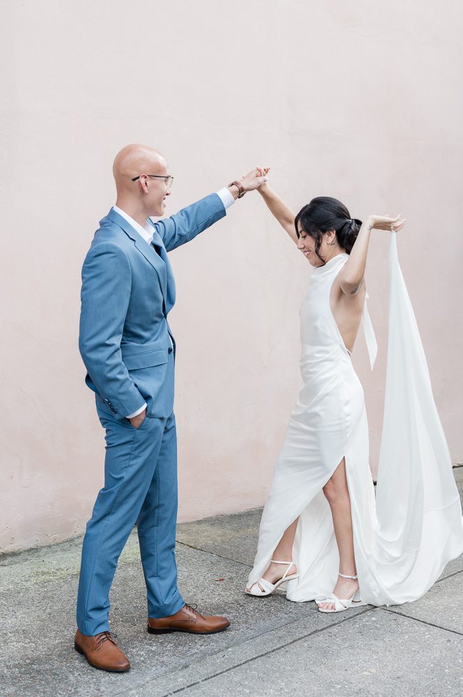 guy twirls his wife in long white dress