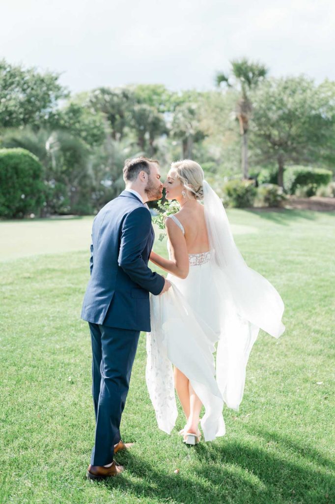 newlyweds walking away stopping for a kiss backlit by the sun