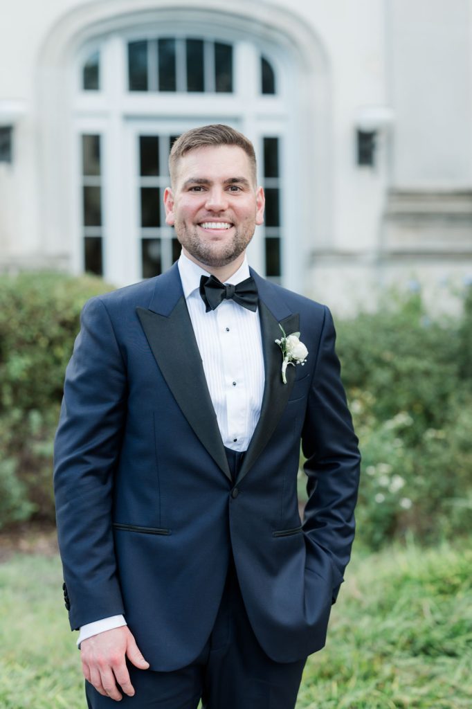 3/4 portrait of brunette groom in navy blue tuxedo