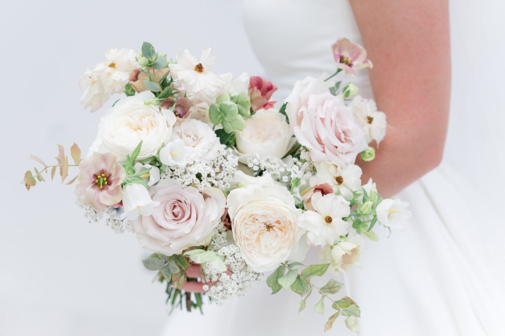 close up of pastel bridal bouquet with pink and white roses