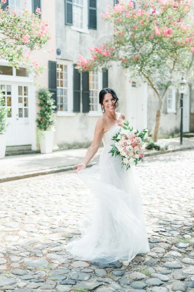bride twirls on cobblestone street