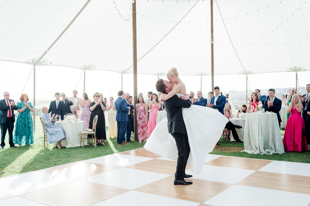 groom lifting bride up during first dance at wedding reception