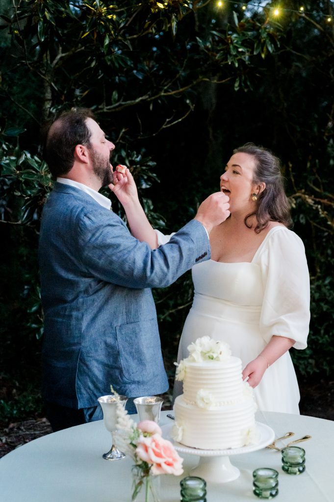 newlyweds feed each other wedding cake by hand