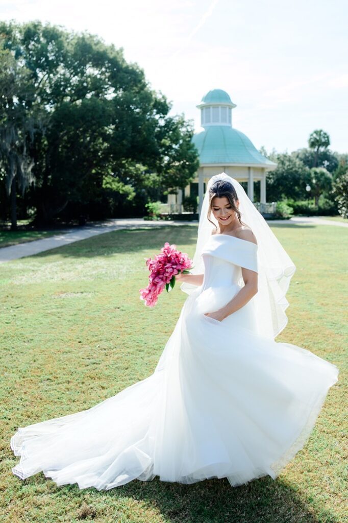 bride swinging wedding dress in front of Gazebo at Hampton Park