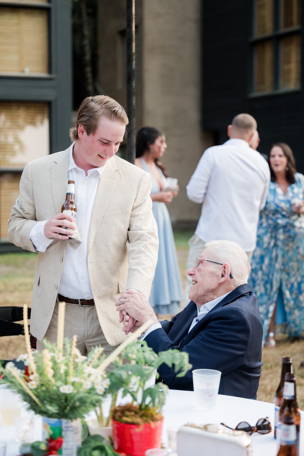 Groom speaking to his grandfather during an Italian-themed rehearsal dinner at Middleton Place